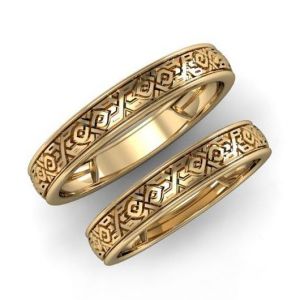 A pair of gold wedding rings with ornament